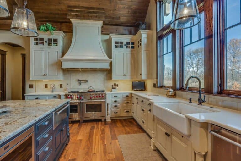 View of sink, oven, and custom kitchen cabinets with stove hood and windows in South Bend Indiana