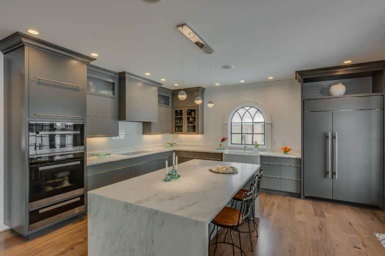 Diagonal view of kitchen with island, custom cabinets, and integrated appliances